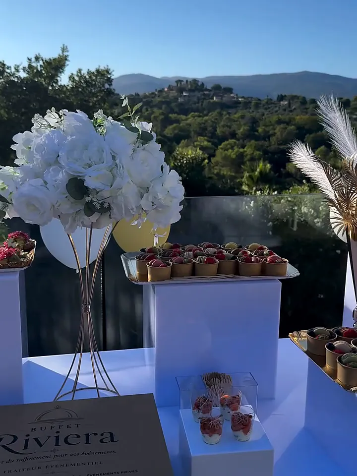 Buffet blanc et or en terrasse avec vue sur les collines et coffret Buffet Riviera