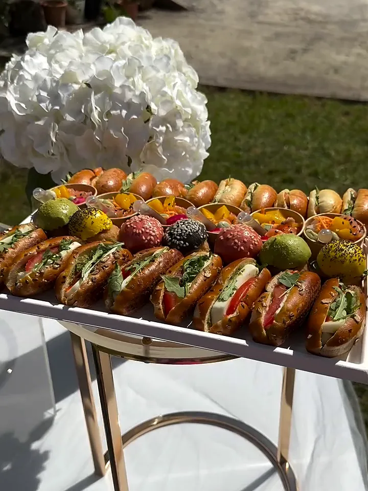 Plateau de sandwichs gourmets et mini burgers colorés dans un jardin, hortensias blancs