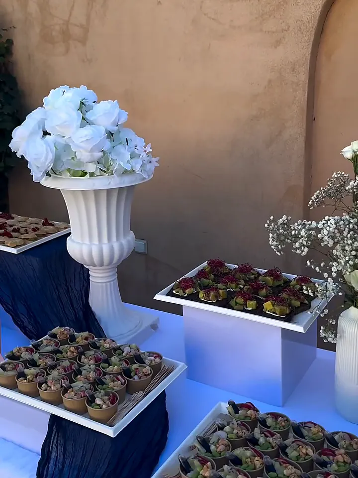 Buffet de mariage blanc et bleu marine : tartelettes, verrines et vasque de roses blanches