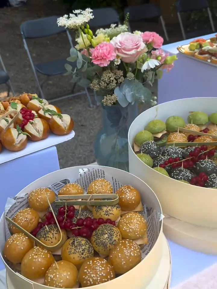 Buffet fleuri avec brioches, pommes d’amour et bouquets de roses
